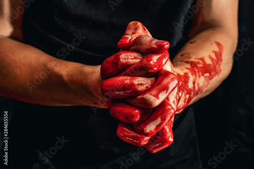 Male hands showing various gestures in the blood on a black background. hands with a gesture of prayer and folded palms