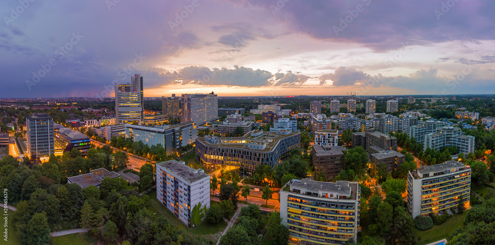 Fototapeta premium Munich from above, a panoramic droneshot in the colorful evening with office bulidings in a working discrict.