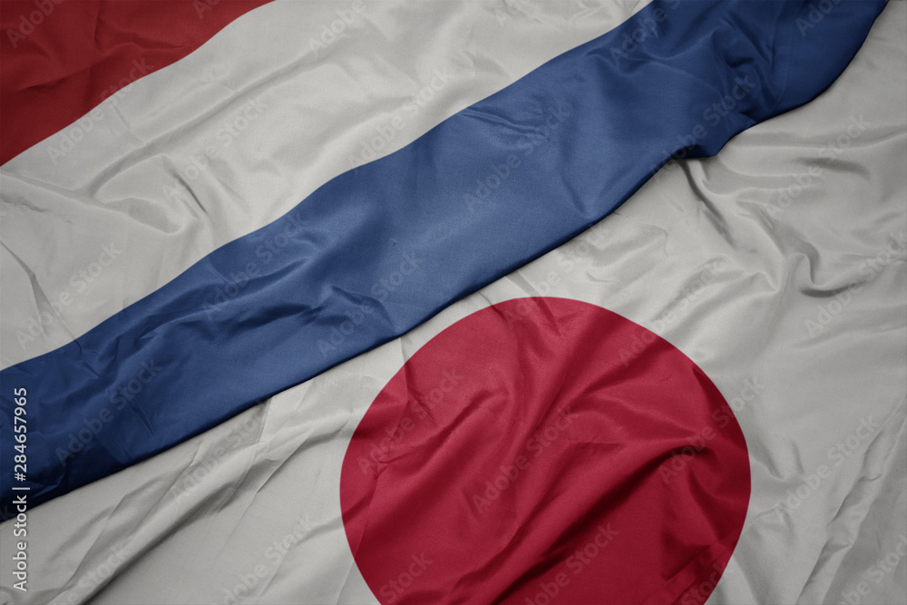 waving colorful flag of japan and national flag of netherlands. waving colorful flag of japan and national flag of netherlands.