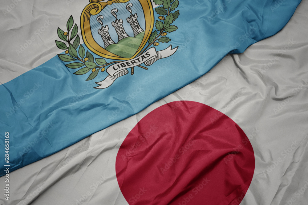 waving colorful flag of japan and national flag of san marino.