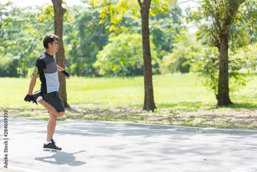 Runners Asian man is warming the body before running. Runners Asian man is warming the body before running.