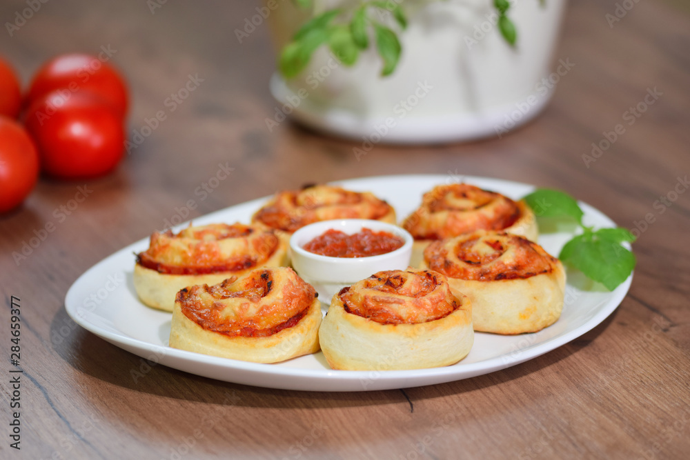 Fresh home made pizza rolls with cheese and tomato sauce. Fresh home made pizza rolls with cheese and tomato sauce.