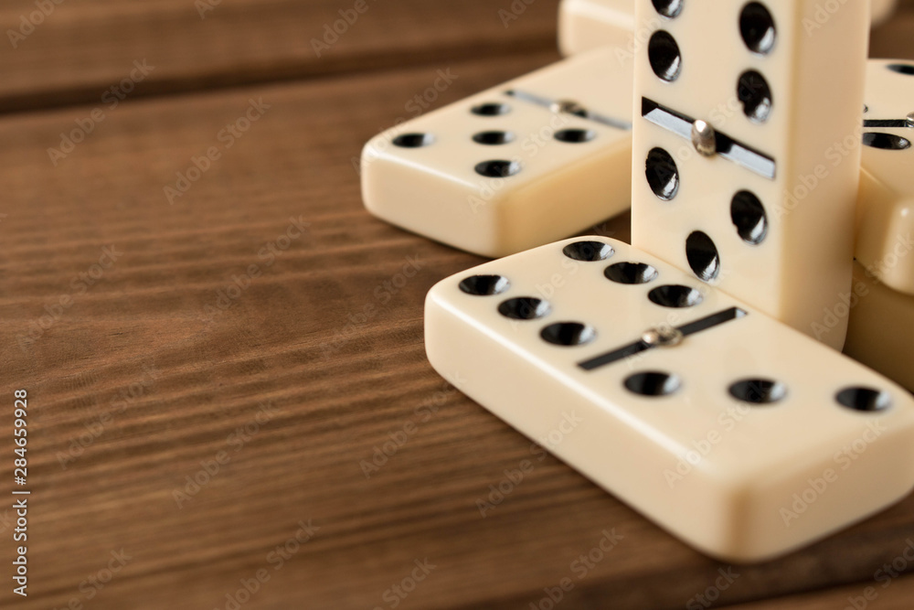 Playing dominoes on a wooden table. Domino effect. Playing dominoes on a wooden table. Domino effect.