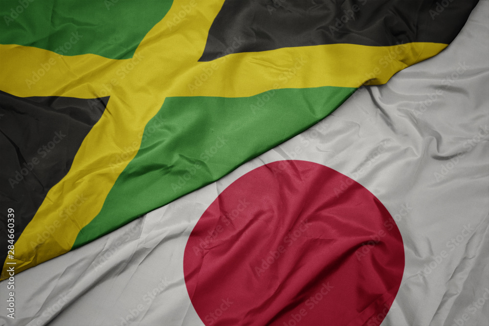 waving colorful flag of japan and national flag of jamaica. waving colorful flag of japan and national flag of jamaica.