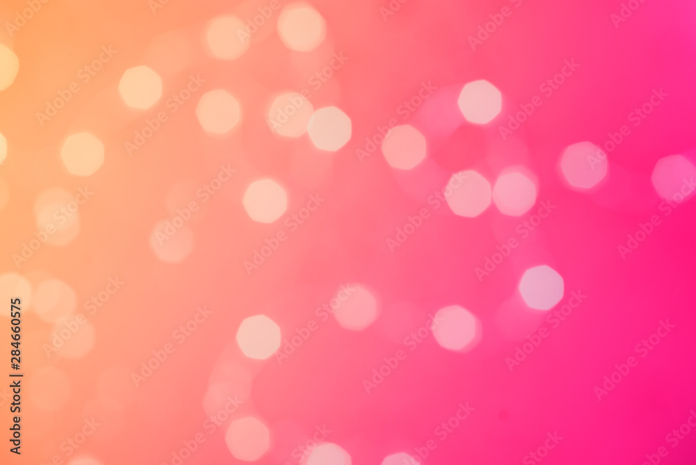 Abstract blurred of orange and pink glittering shine bulbs lights background: blur of Christmas wallpaper decorations concept