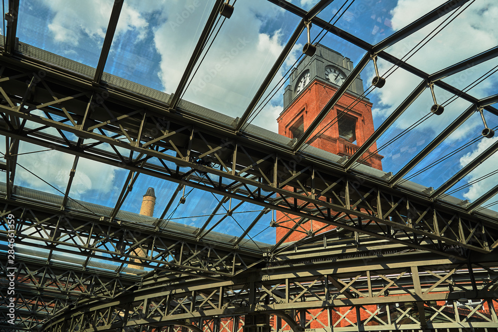 Clock tower and metal structure of the glass roof in the old brewery in Poznan. Clock tower and metal structure of the glass roof in the old brewery in Poznan.