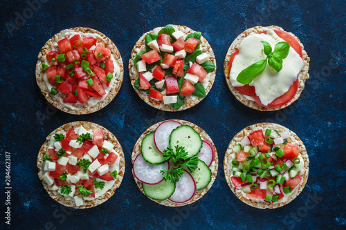 various healthy sandwiches with rice cake chopped tomatoes radish cucumber basil cheese green onion top view