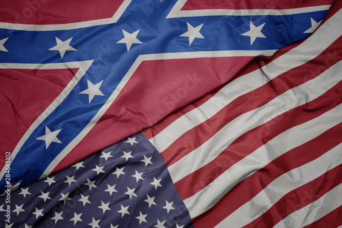 Photos waving colorful flag of united states of america and confederate flag