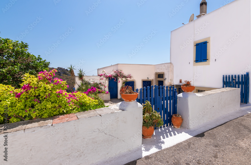 Obraz premium Chora town with white Greek house, courtyard and decorative pottery along the street, Kythira Island, Greece.