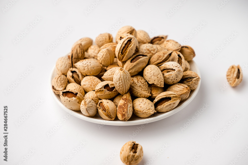 Obraz premium tasty nutritious shell almonds on a white background