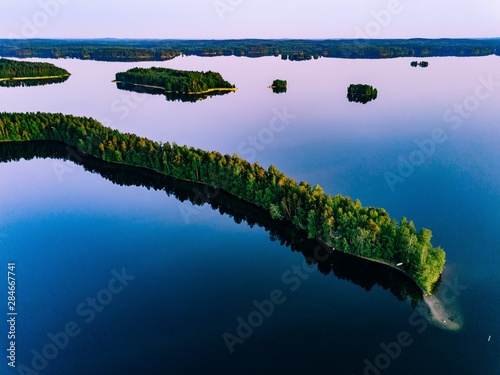 Aerial view of blue lakes with islands and green forests  in Finland. © nblxer
