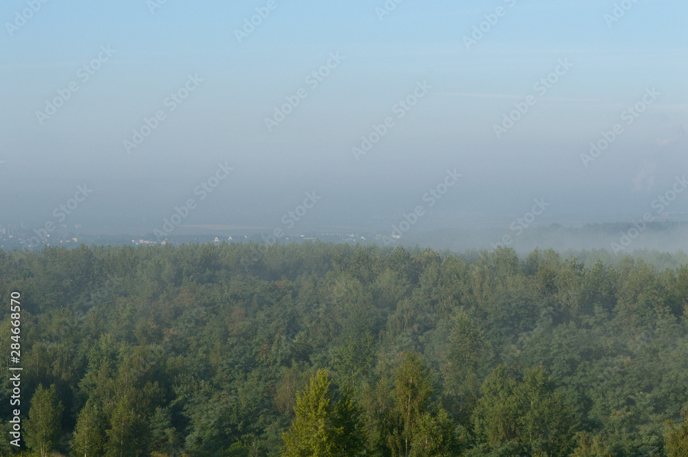 Fog over small town and forest hills in Silesia, Poland, Europe