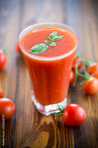 homemade tomato juice in a glass and fresh tomatoes