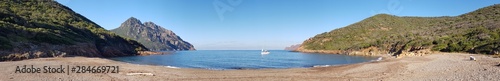 Panoramique d'une crique au petit matin, entre mer et montagne