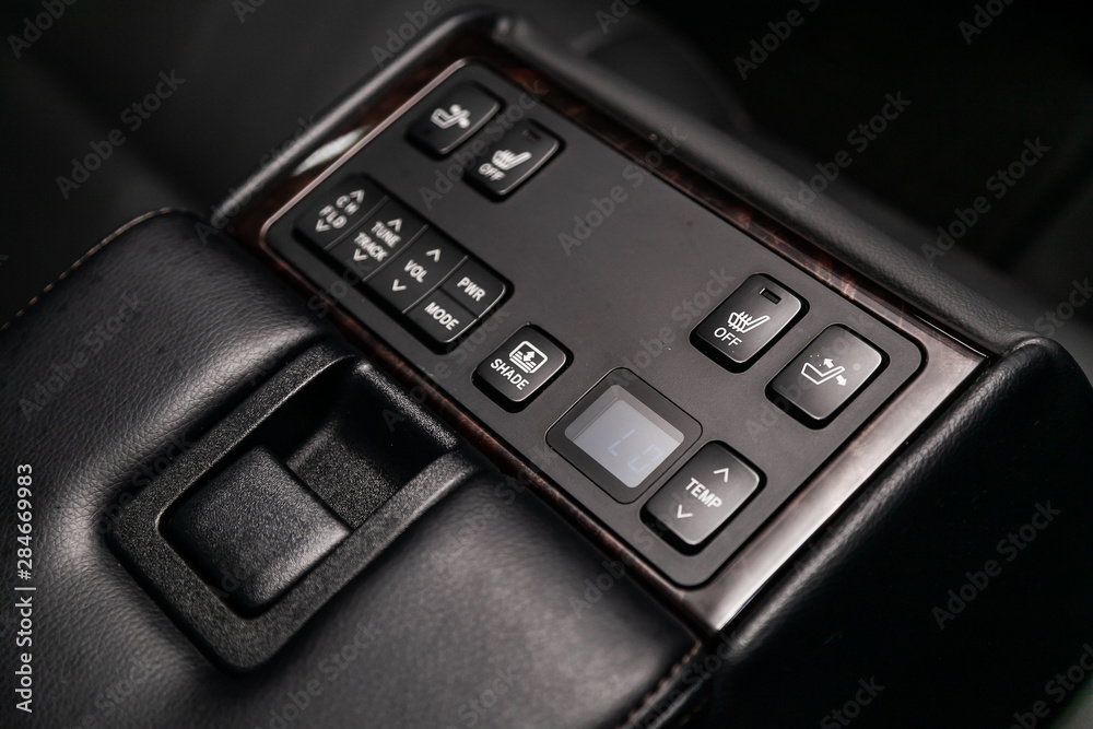 Close-up on the shade lock, seat heatting, seat adjustment , parking radar,Temperature regulator  switch control buttons,  automatic adjust level dashboard. modern car interior: parts, buttons, knobs.