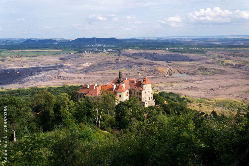 Jezeri Castle with Czechoslovak army coal mine in background, Horni Jiretin, Most district, Ustecky region, Czech Republic, sunny summer day Jezeri Castle with Czechoslovak army coal mine in background, Horni Jiretin, Most district, Ustecky region, Czech Republic, sunny summer day