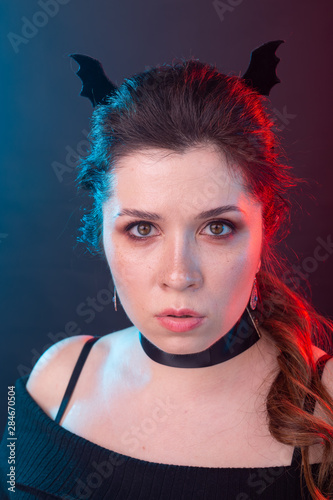 Halloween, holidays and carnival concept - portrait of woman in gothic style is looking very serious