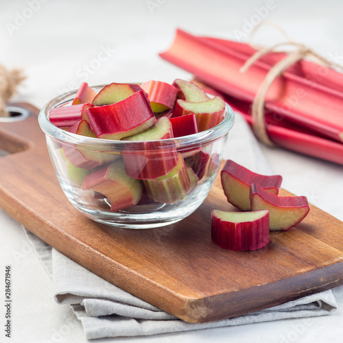 Tableau sur toile Cutted rhubarb in a glass dish and on a wooden board, square