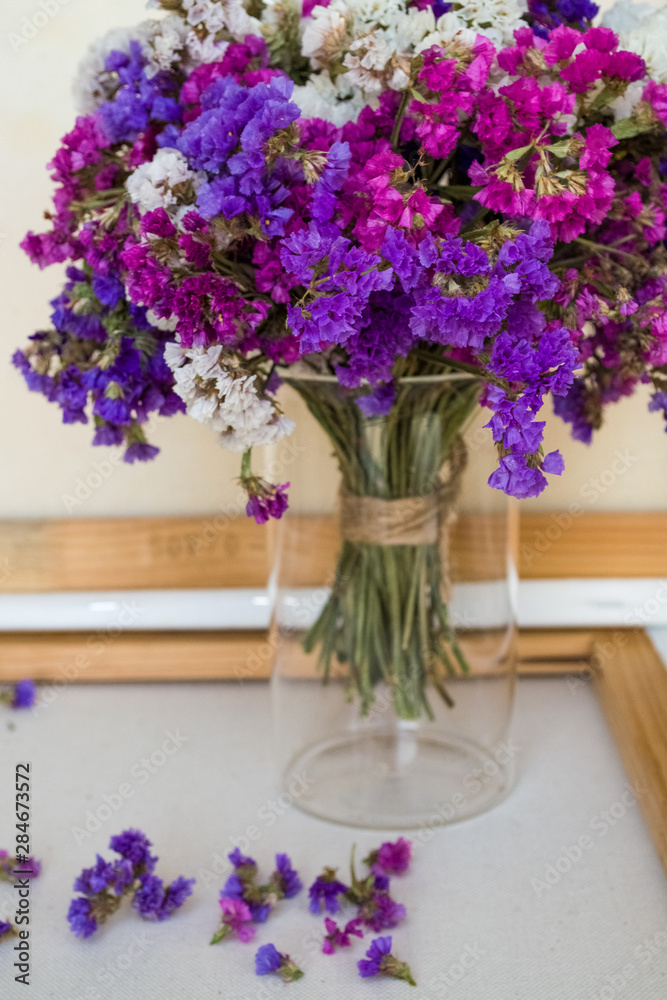 A bouquet of field purple flowers in a glass flask. Vase. Still life. White background. A bouquet of field purple flowers in a glass flask. Vase. Still life. White background.
