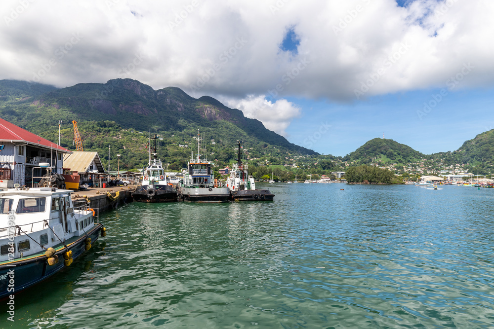 Port Victoria on Seychelles island mahé with mountain range in the background, ships and blue water in front