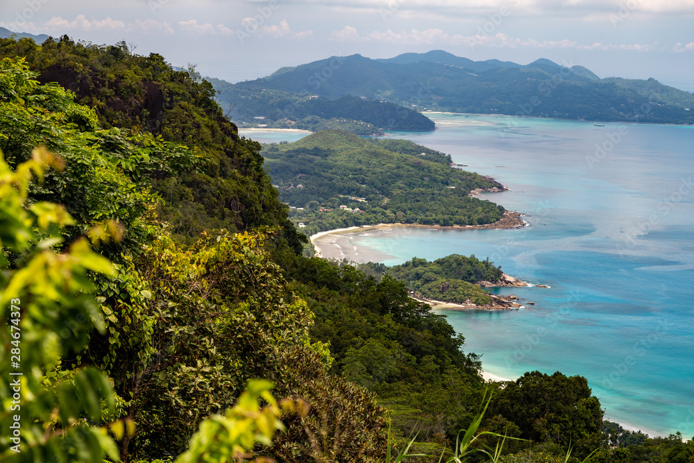 Panoramic view at the landscape on Seychelles island Mahé with clear blue water and green mountains