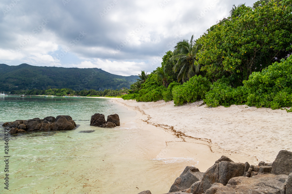Paradise beach anse royale on Seychelles island Mahé with turguoise water, palms, white sand and granite rocks