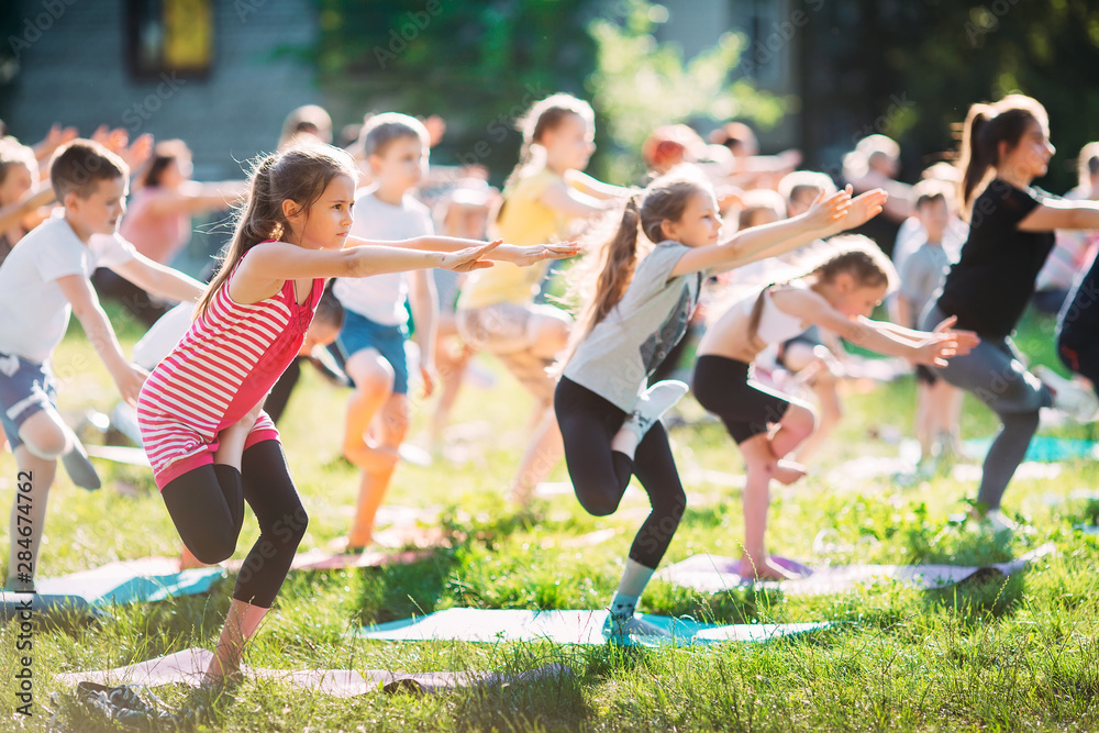 Obraz premium Yoga classes outside on the open air. Kids Yoga,