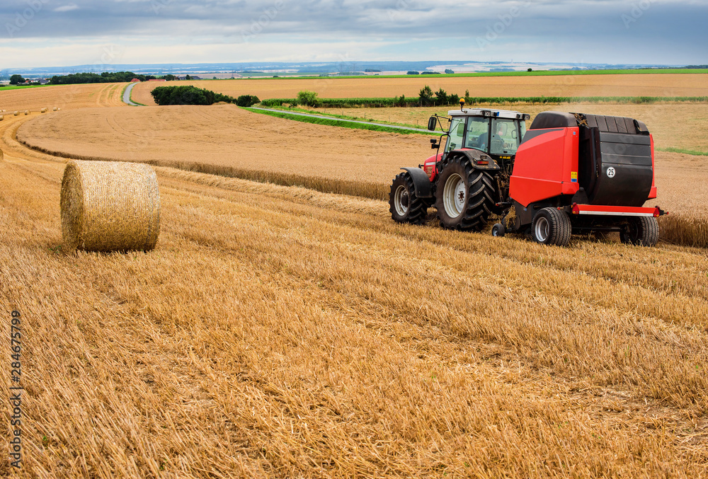 farmer in fields making straw bales farmer in fields making straw bales