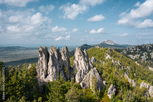 aerial view of russian national park Taganay. drone flying down near steep stony slope of mount overgrown with deep taiga forest of oldest mountain range in the world. beautiful scenery of wild nature