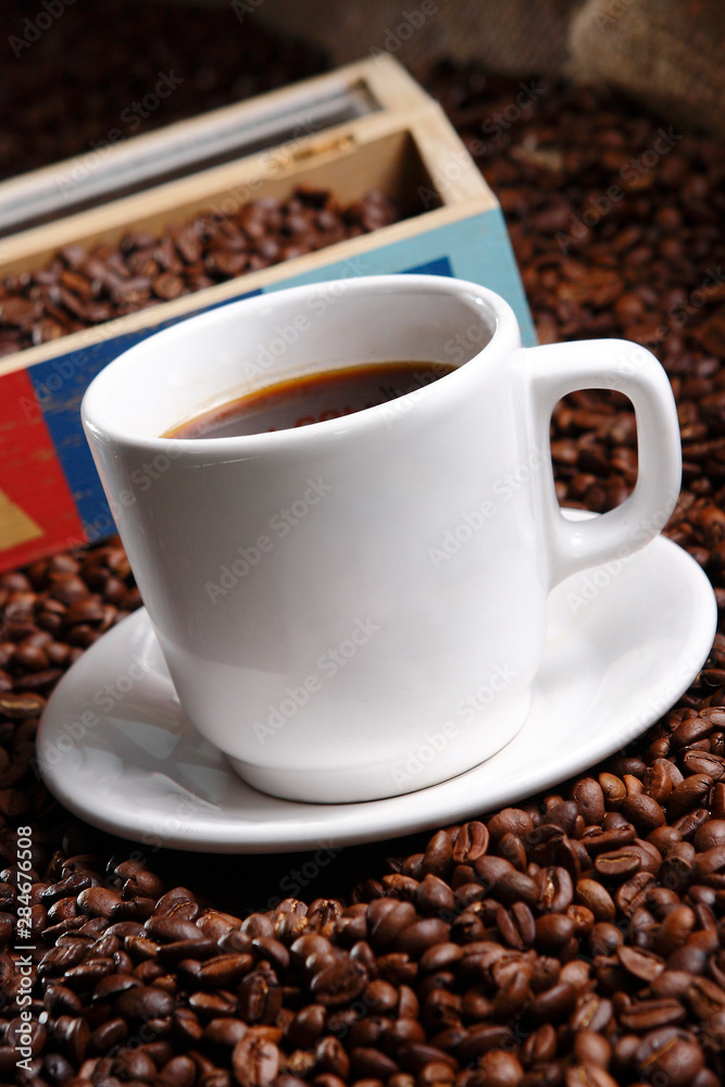 Coffee with grains and sweet bread. Coffee is a brewed drink prepared from roasted coffee beans, the seeds of berries from certain Coffea species.