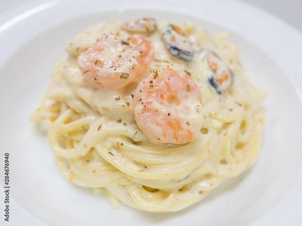 Pasta Carbonara with seafood on a white plate