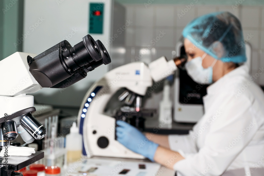 Scientist woman looking through microscope in laboratory Microscope in laboratory, analyzes. Scientist woman looking through microscope in laboratory Microscope in laboratory, analyzes.