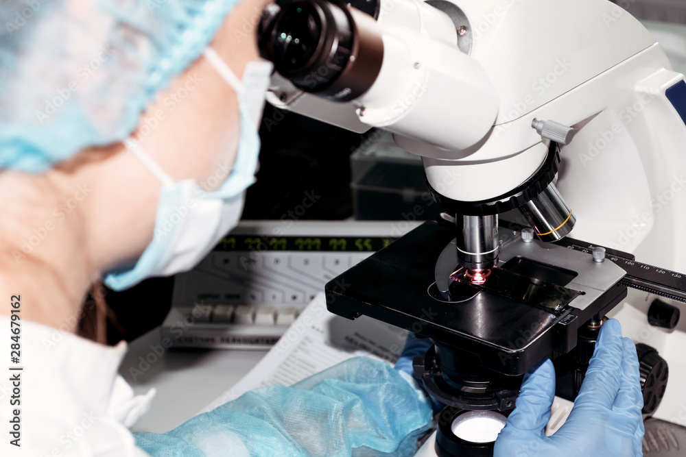 Scientist woman looking through microscope in laboratory Microscope in laboratory, analyzes. Scientist woman looking through microscope in laboratory Microscope in laboratory, analyzes.