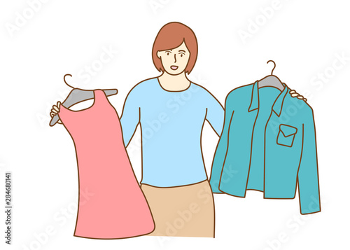 Young woman choosing clothes, the woman trying on new clothes