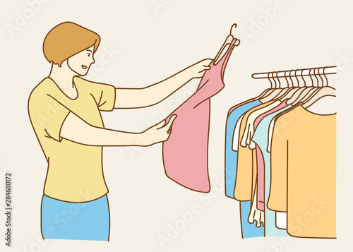 Young woman choosing clothes, the woman trying on new clothes