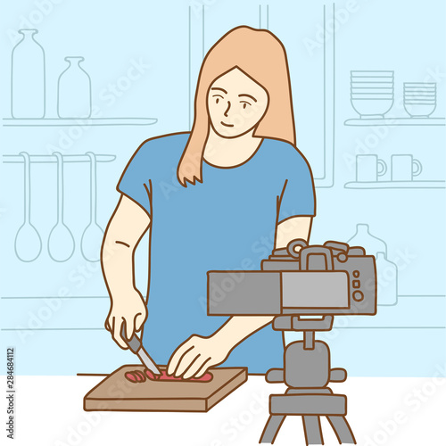 Camera recording a young female blogger cooking while making a video