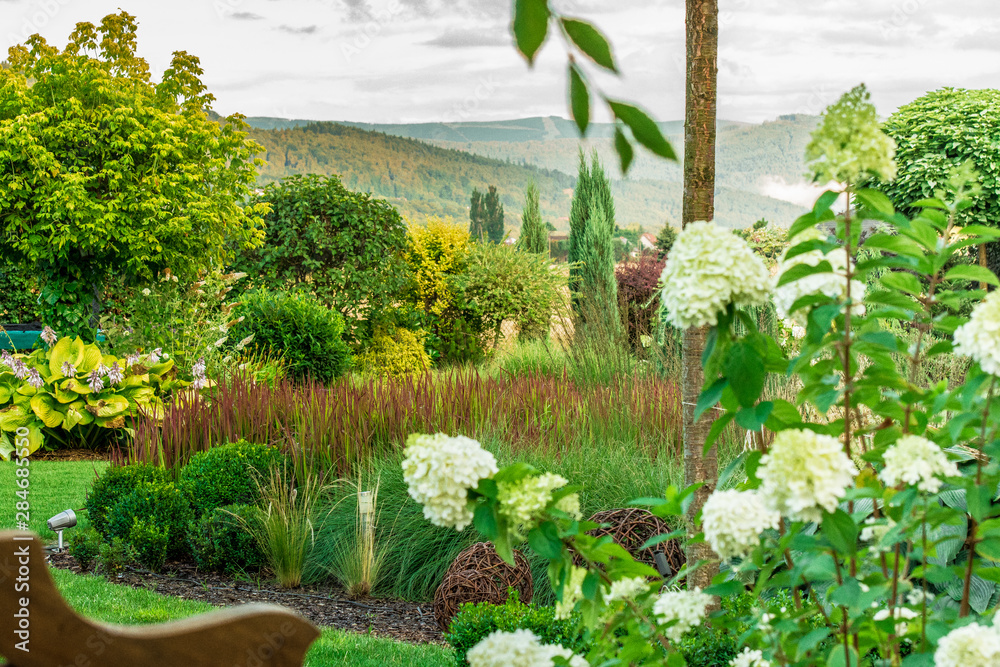 Obraz premium Piękny zielony ogród z widokiem na góry