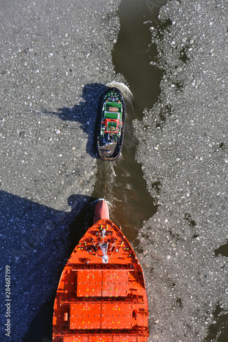 Hamburger Hafenschlepper zieht ein Schiff der Reederei Hamburg Sued photo