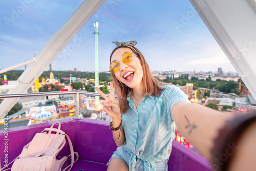 Photography Happy asian woman smiling and taking selfie photo on a ferris wheel