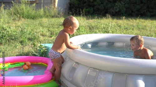 A little boys is playing in colorful inflatable pools with waters. Summer and family holidays. Happy childhood