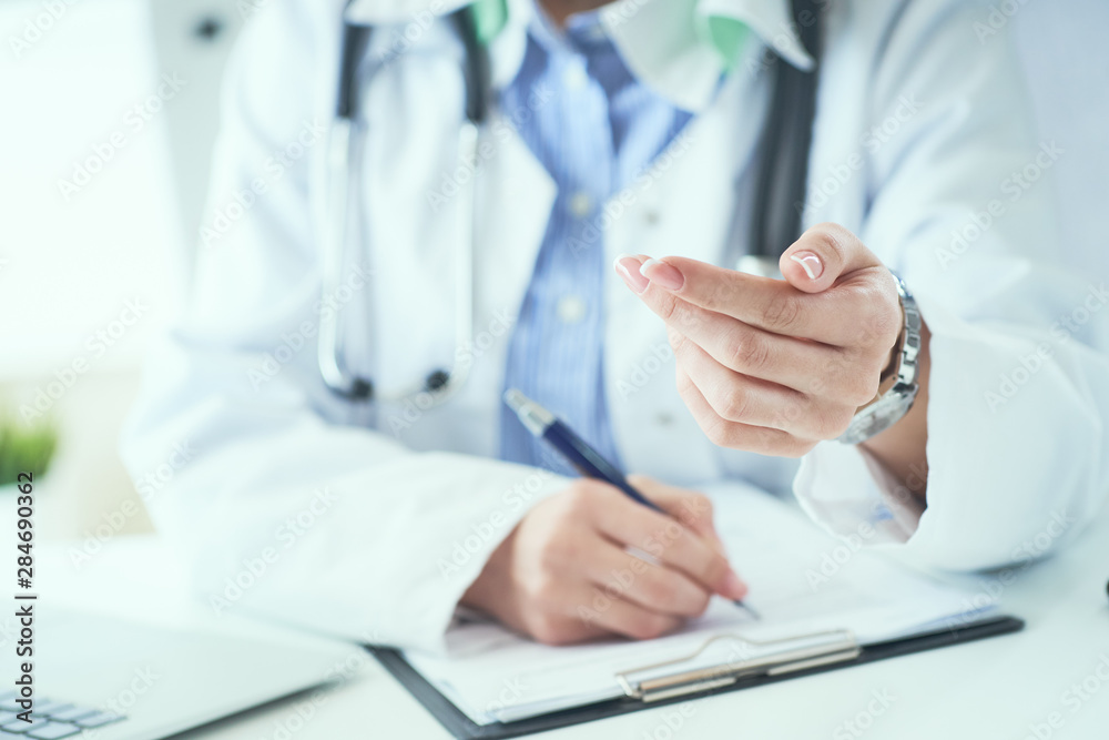 Female doctor explaining patient symptoms or asking a question as they discuss together in a consultation. Doctor held out his hand to the patient close-up. Female doctor explaining patient symptoms or asking a question as they discuss together in a consultation. Doctor held out his hand to the patient close-up.