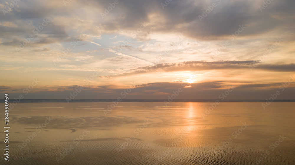 Beautiful view of the sea and sunset. Aerial view from flying drone of a beautiful nature landscape with dramatic clouds sunset sky and views of the sea surface. Postcard view. Nature