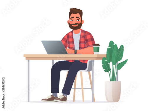 Business man at the desktop with a laptop. Freelancer or office worker
