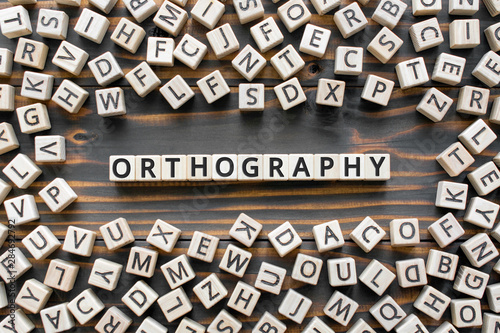orthography - word from wooden blocks with letters, *** concept, random letters around, white background