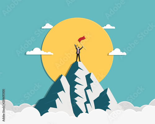 Businessman holding a red flag and gold trophy stand on top of mountain