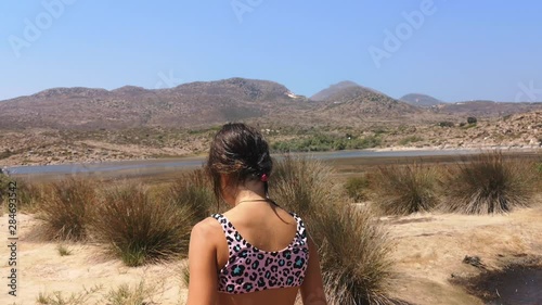 A young girl walking around small lakes in a empty, remote area of Greece photo