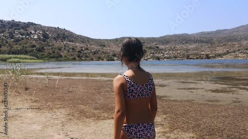 A young girl decides which way to go as she explores Achivadolimni Milos Island photo