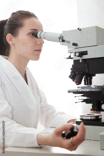 Obraz na plátně Laboratory assistant uses a polarizing microscope in a microbiological laborator