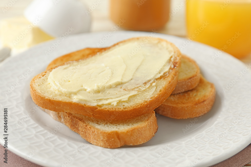 Tasty bread with butter on white plate, closeup Tasty bread with butter on white plate, closeup