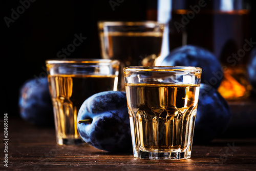 Fotografie Slivovica - plum brandy or plum vodka, hard liquor, strong drink in glasses on o